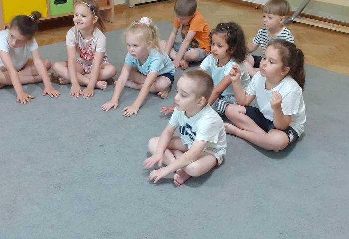 Grupa III - Dzieci siedzą na dywanie w strojach gimnastycznych