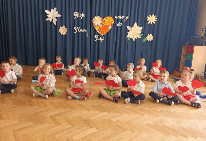 Grupa III - Dzieci siedzą na scenie z sercami
